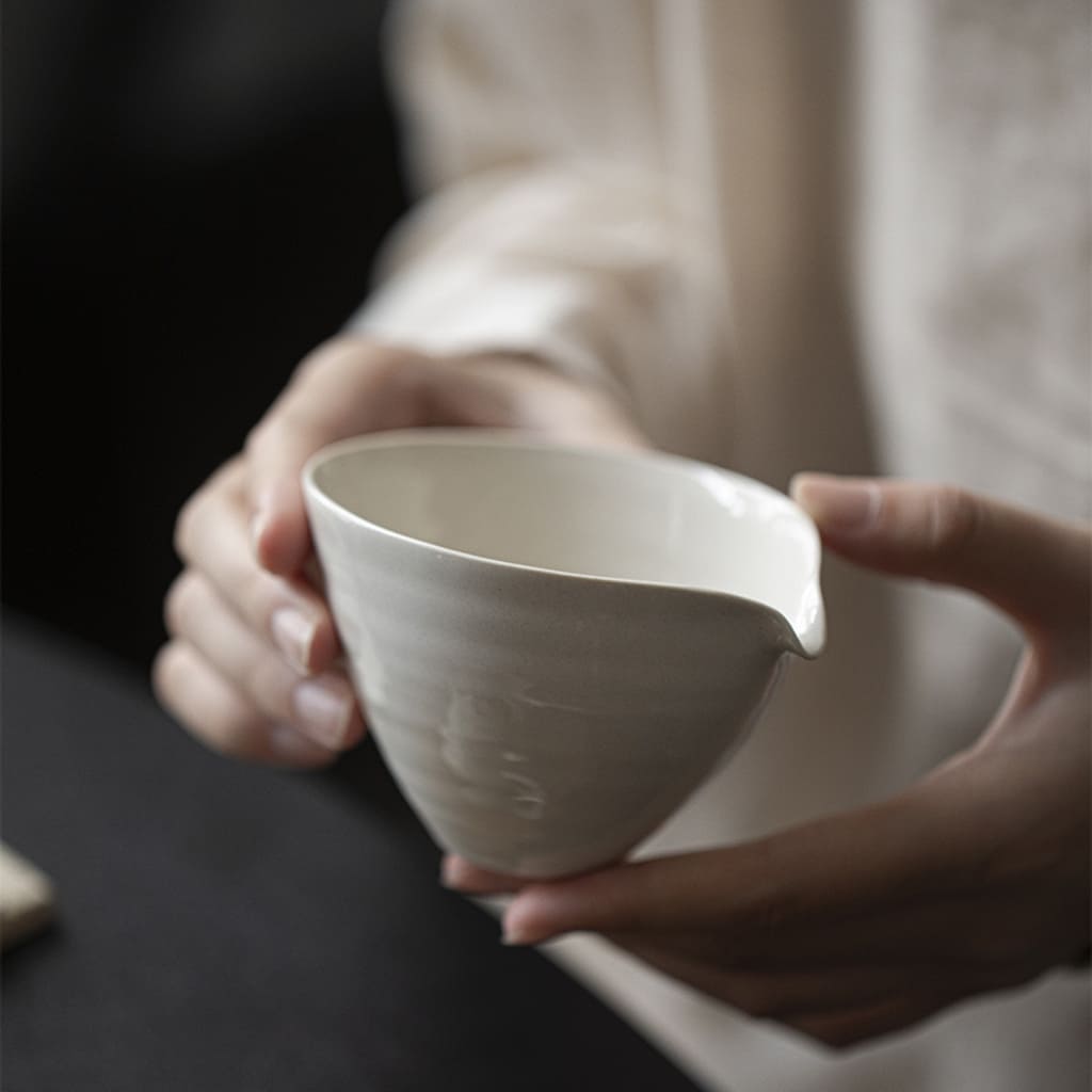 Person holding the grey glaze porcelain Cha Hai