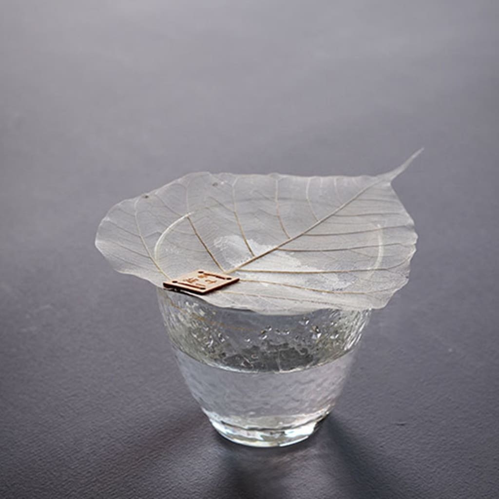 Clear glass tea cup with the ficus religiosa leaf strainer